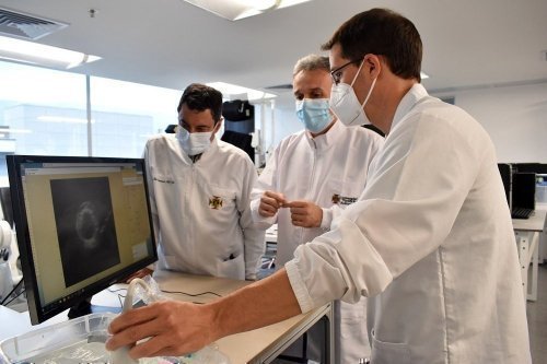 Estudiantes con vestuario de medicina analizando radiografía en computador