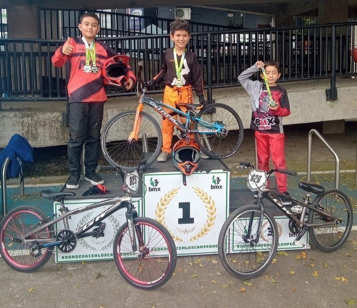 Competidores de BMX parados en el podio 