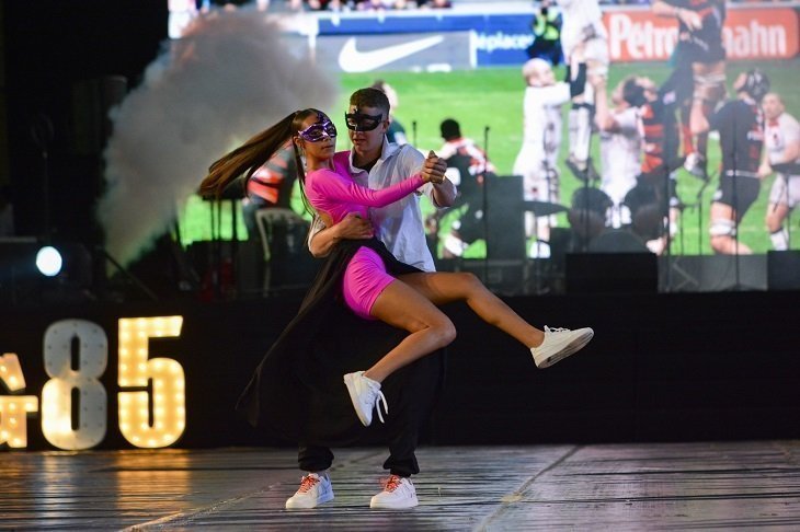 dos estudiantes bailando con movimientos donde la joven esta alzada