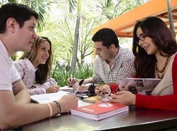 Estudiantes reunidos en una mesa haciendo trabajos