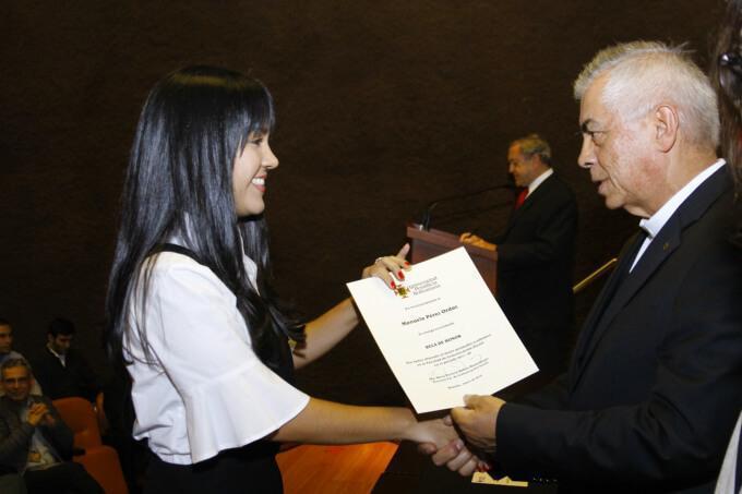 Estudiante destacada recibiendo el diploma de Becaria de honor