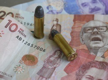 Dinero colombiano con balas