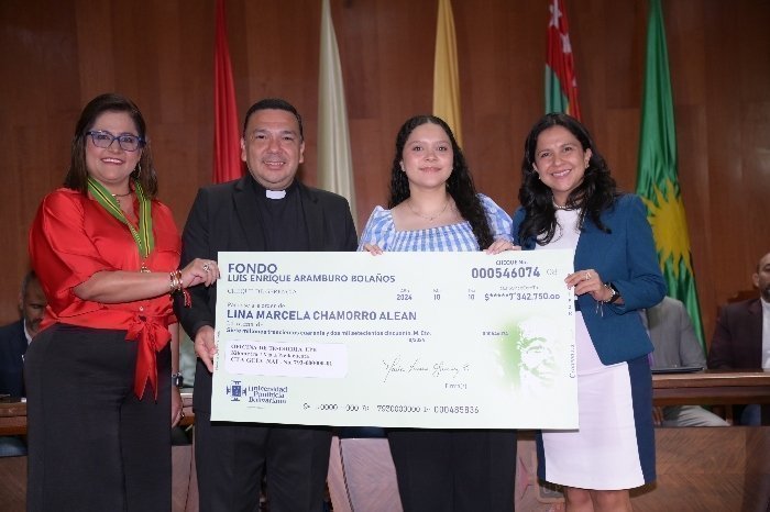 Docentes y Rector UPB posando para una fotografía. Una persona tiene un reconocimiento en sus manos.