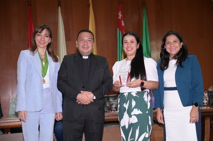 Docentes UPB posando para una fotografía. Una persona tiene un reconocimiento en sus manos.