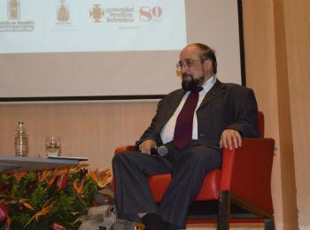 Guillermo León Escobar sentado en el escenario del Aula Magna de la UPB dictando una conferencia
