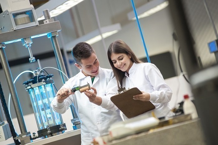 Dos personas revisando su trabajo en un laboratorio de la UPB