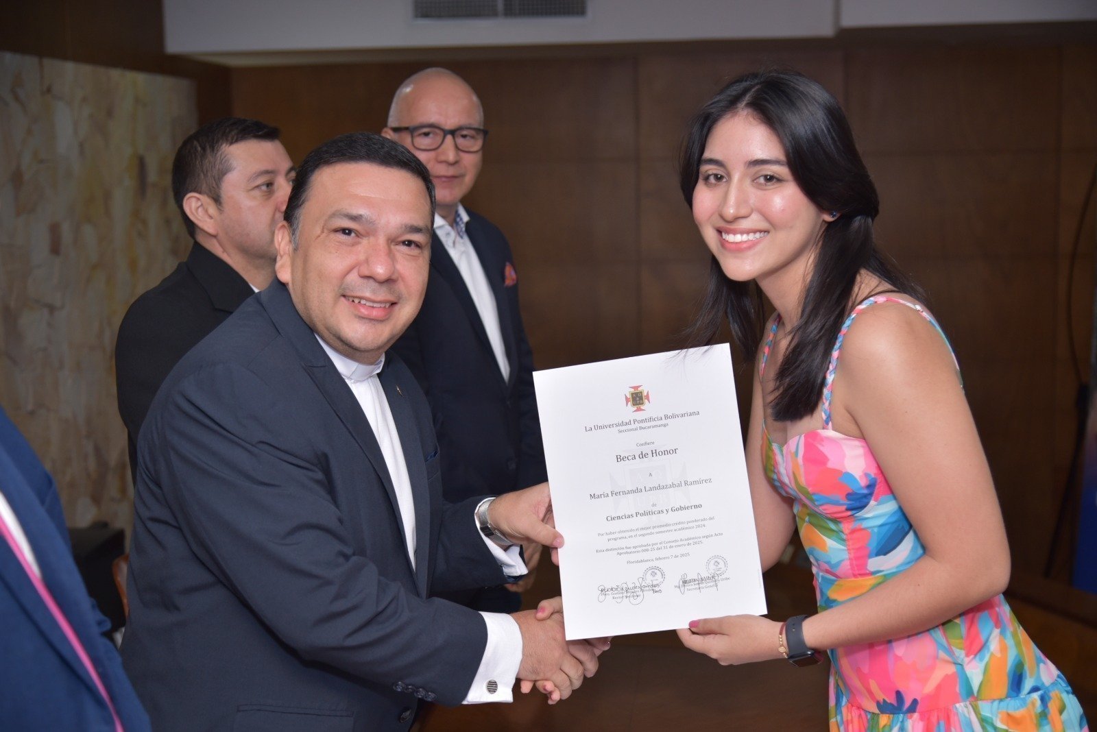 El rector de la Universidad Pontificia Bolivariana Seccional Bucaramanga entrega la Beca de Honor a una estudiante destacada, en reconocimiento a su excelencia académica durante la ceremonia de becas.