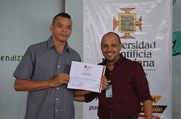 de izquierda a derecha: Germán Pineda, beneficiado, Euler Vargas, Director de la Facultad de Publicidad