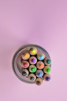 Dentro de un vaso se encuentran colores con las puntas hacie arriba.