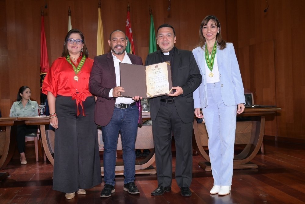 Cuatro personas con reconocimientos posando para una fotografía