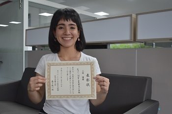 la mejor estudiante de japones sosteniendo su diploma